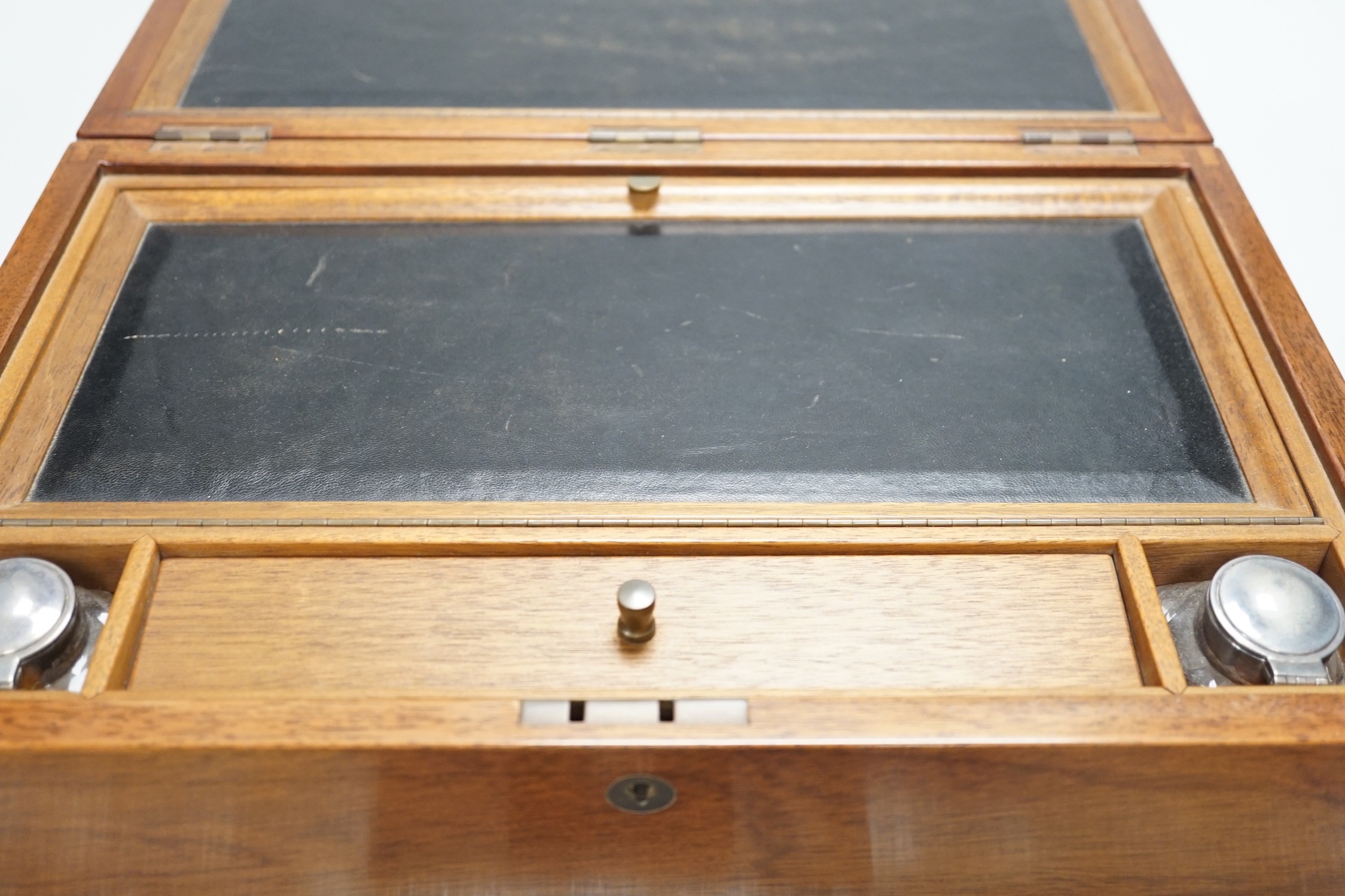 An inlaid mahogany writing slope with two silver-mounted inkwells, 39cm wide